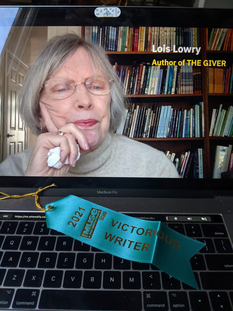 Lois Lowry video on laptop with "victorious writer" ribbon on keyboard