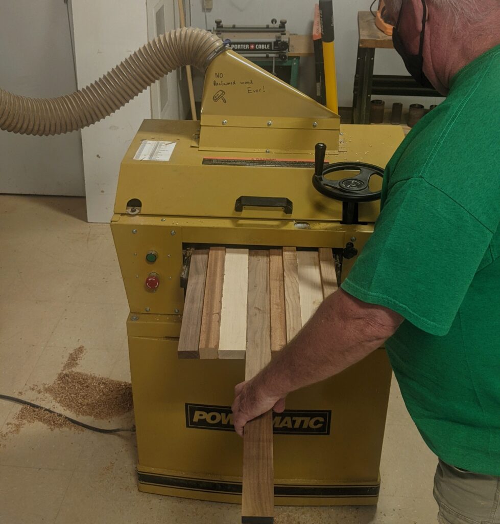 Pizza peel base running through a planer.